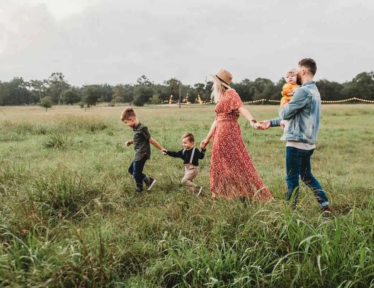 family in field celebrating their social responsibility with solar panels