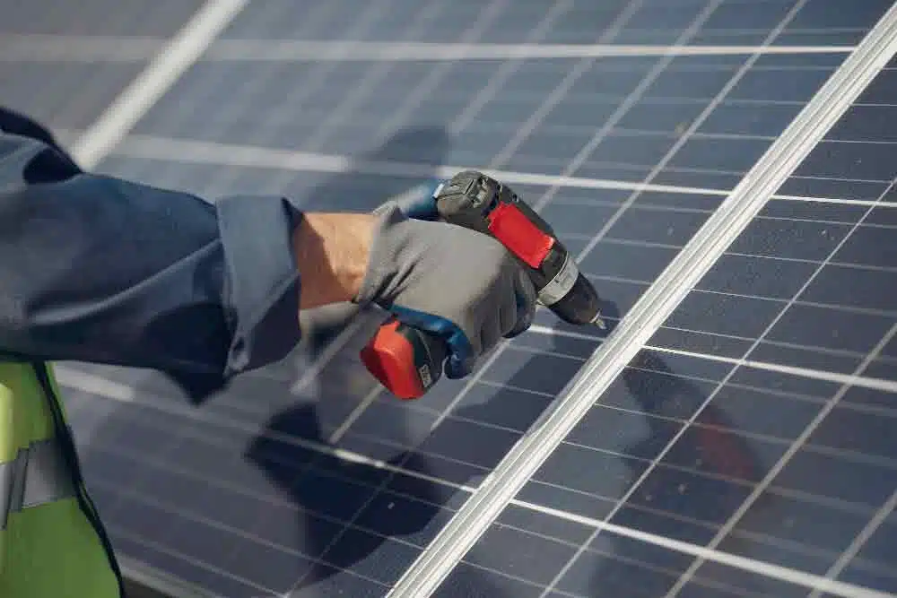 man with white helmet near solar panels